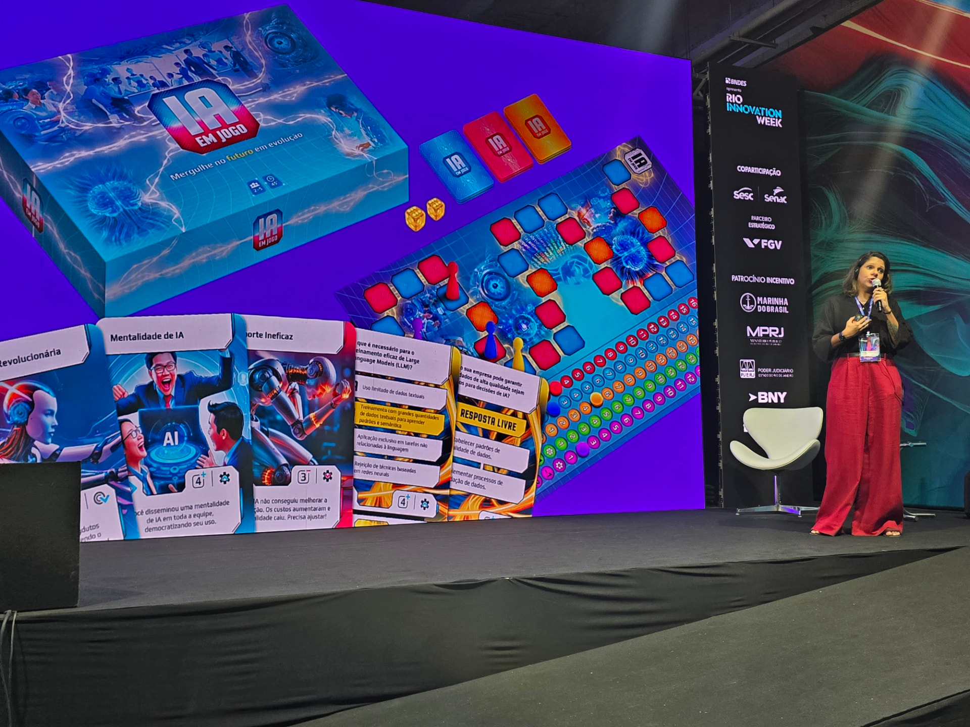 Luna Paladino no palco da Rio Innovation Week com o IA EM JOGO no telão